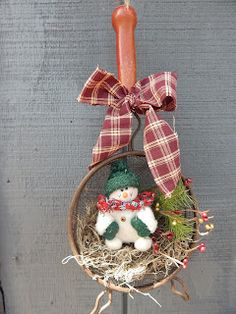 a christmas ornament with a snowman in a basket and a lit candle