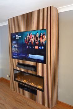 a flat screen tv mounted to the side of a wooden wall next to a fire place