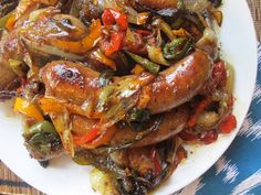 a white plate topped with sausages and peppers