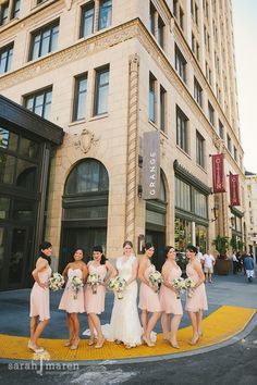 a group of women standing next to each other in front of a building