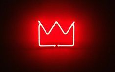 a red neon sign with a crown on it's side, lit up in the dark