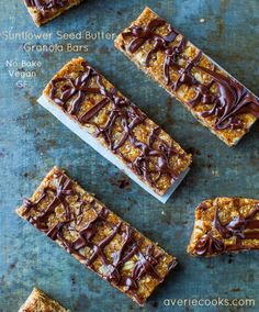 four pieces of food sitting on top of a blue surface with chocolate drizzled over them