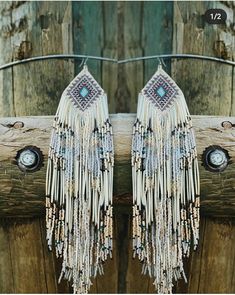 a pair of white earrings with beads and chains hanging from it's ear ends