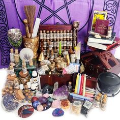 an assortment of items are displayed on a purple table cloth and in front of a wooden trunk