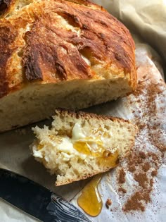 a loaf of bread sitting on top of a piece of paper next to a knife