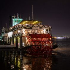 a large boat floating on top of a body of water next to a pier at night