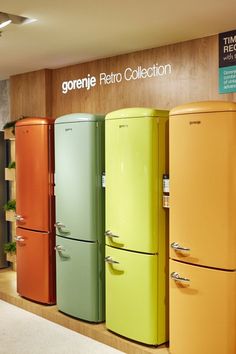 the colorful refrigerators are lined up against the wall in the store's display area