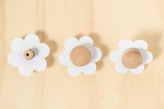 three wooden flowers are placed next to each other