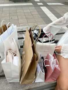 a woman sitting on a bench holding shopping bags