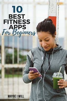 a woman is looking at her cell phone while holding a drink and listening to headphones