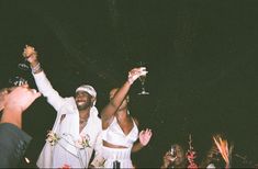 two people holding up wine glasses at a party