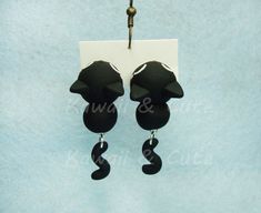 Black cat earrings simulating to be biting your ear, inspired in a cute design of a tiny black kitty. Totally handmade in polymer clay with a lot of care and love. All the details in the piece are made with polymer clay, even the tiniest details like eyes, nose, cheeks... Nothing is painted. This makes each piece unique and exclusive; therefore, there may be very very slight differences with the provided picture. Very light and confortable to wear. Length 3 cm Width 1,5 cm Composition Polymer cl Kawaii Black Jewelry Gift, Cute Black Dangle Jewelry, Cute Cat Ears Earrings With Cat Print, Cute Black Hypoallergenic Jewelry, Cute Black Cat Design Earrings, Cute Black Pierced Jewelry, Cute Black Earrings As A Gift, Playful Black Earrings For Gift, Cute Black Earrings For Gifts