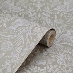 a roll of tape sitting on top of a wallpaper covered in white floral designs