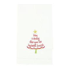 a white dish towel with a christmas tree on the front and words written in red