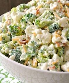 broccoli cauliflower salad in a white bowl on a green and white tablecloth