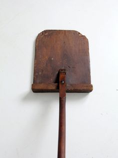 an old wooden spatula hanging on the wall