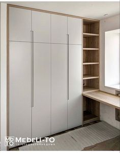 an empty room with white cupboards and shelves