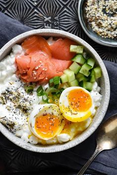 a bowl filled with eggs, salmon and cucumbers