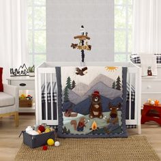 a baby crib bedding set with animals and trees on it in a nursery