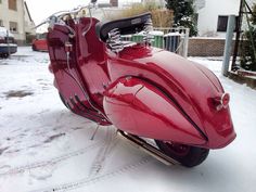 a red motorcycle is parked in the snow