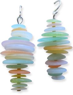 two pairs of multicolored earrings hanging from hooks