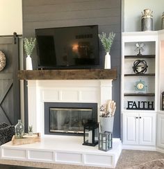 a living room with a fireplace, television and other items on the mantle in front of it