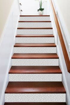 the stairs are painted white and have wood treads on each side, along with a potted plant