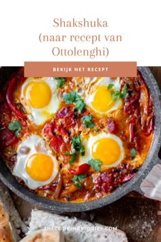 a pan filled with eggs and cheese on top of a wooden table next to bread