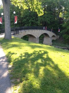 a stone bridge over a small stream in a park