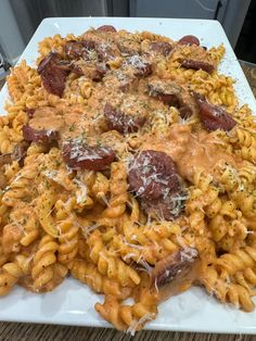 a white plate topped with pasta covered in sauce and meatballs on top of it