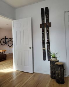 two skis are hanging on the wall next to a potted plant and door