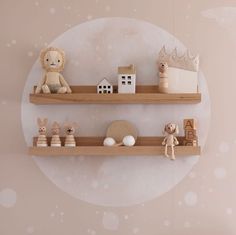 two wooden shelves with toys on them in front of a pink wall and white polka dot background