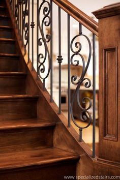 a wooden stair case with wrought iron handrails