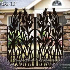 an iron gate in front of a house with lavenders on the outside and behind it