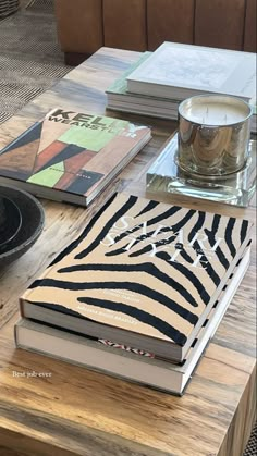 a wooden table topped with books next to a glass cup