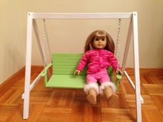 a doll is sitting on a green swing