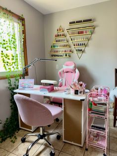 a pink chair sitting in front of a desk with lots of crafting supplies on it