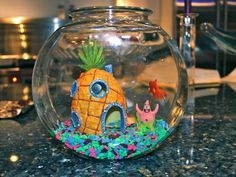 a fish bowl with a pineapple house in it