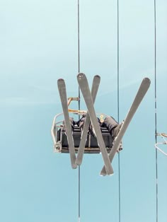 two skis are suspended in the air by wires