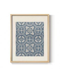 a blue and white print hanging on the wall next to a wooden framed art piece