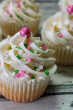 several cupcakes with white frosting and sprinkles on the top