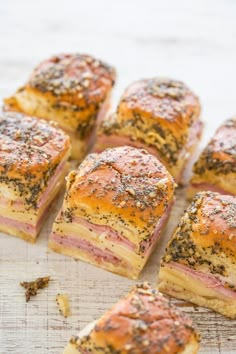 ham and cheese sliders are arranged on a cutting board, ready to be eaten