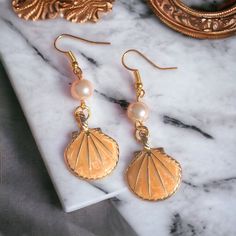 Handmade pale orange pearl and shell earrings. Made in Chichester with loving care. All orders come packed within a lovely Oganza bag. Lovely to wear for any occasion. Statement earrings. Length - 5cm Width - 3cm Made to order and dispatched in one working day. Free standard 2nd class delivery. Upgrade to 1st class for 90p with our express delivery service.  Any questions always feel free to ask, I will respond back very quickly. Thank you ❤️ Shell-shaped Pearl Earrings For Gift, Shell-shaped Pearl Drop Earrings For Gifts, Pearl Drop Shell As A Gift, Shell-shaped Pearl Charm Earrings As Gift, Elegant Shell Pearl Earrings For Gift, Pearl Shell Earrings Perfect For Gifts, Shell Shaped Pearl Earrings For Gift, Pearl Shell Earrings For Gift, Pearl Drop Shell-shaped Earrings For Gift