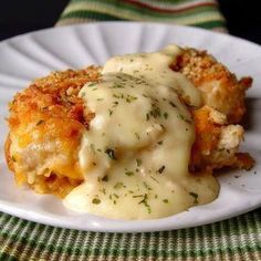 crispy cheddar chicken on a white plate with gravy and parsley