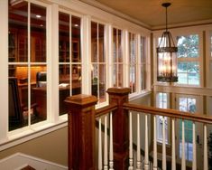 the inside of a house with many windows and railings on each side of the room