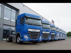 a row of blue trucks parked in front of a building