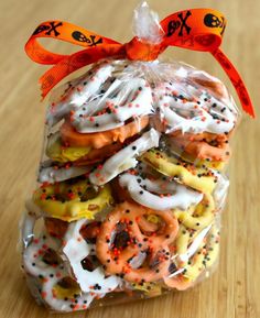 a bag filled with donuts and sprinkles on top of a wooden table