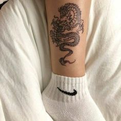 a person with a dragon tattoo on their arm