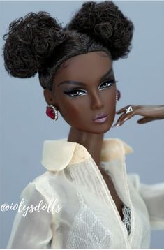 a black doll with curly hair and earrings