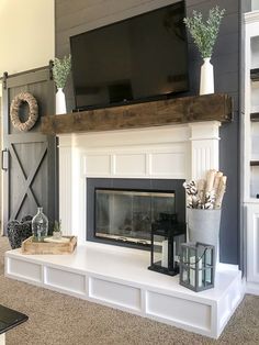 a living room with a fireplace and television on top of the mantel in front of it